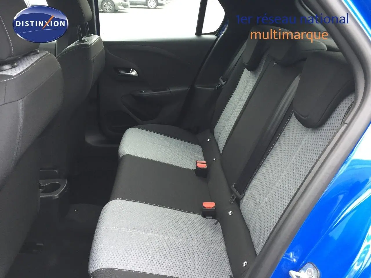 Vue côté droit de l'habitacle arrière d'une Opel Corsa bleu voltaik metal, avec sièges tissu bicolore gris et noir.