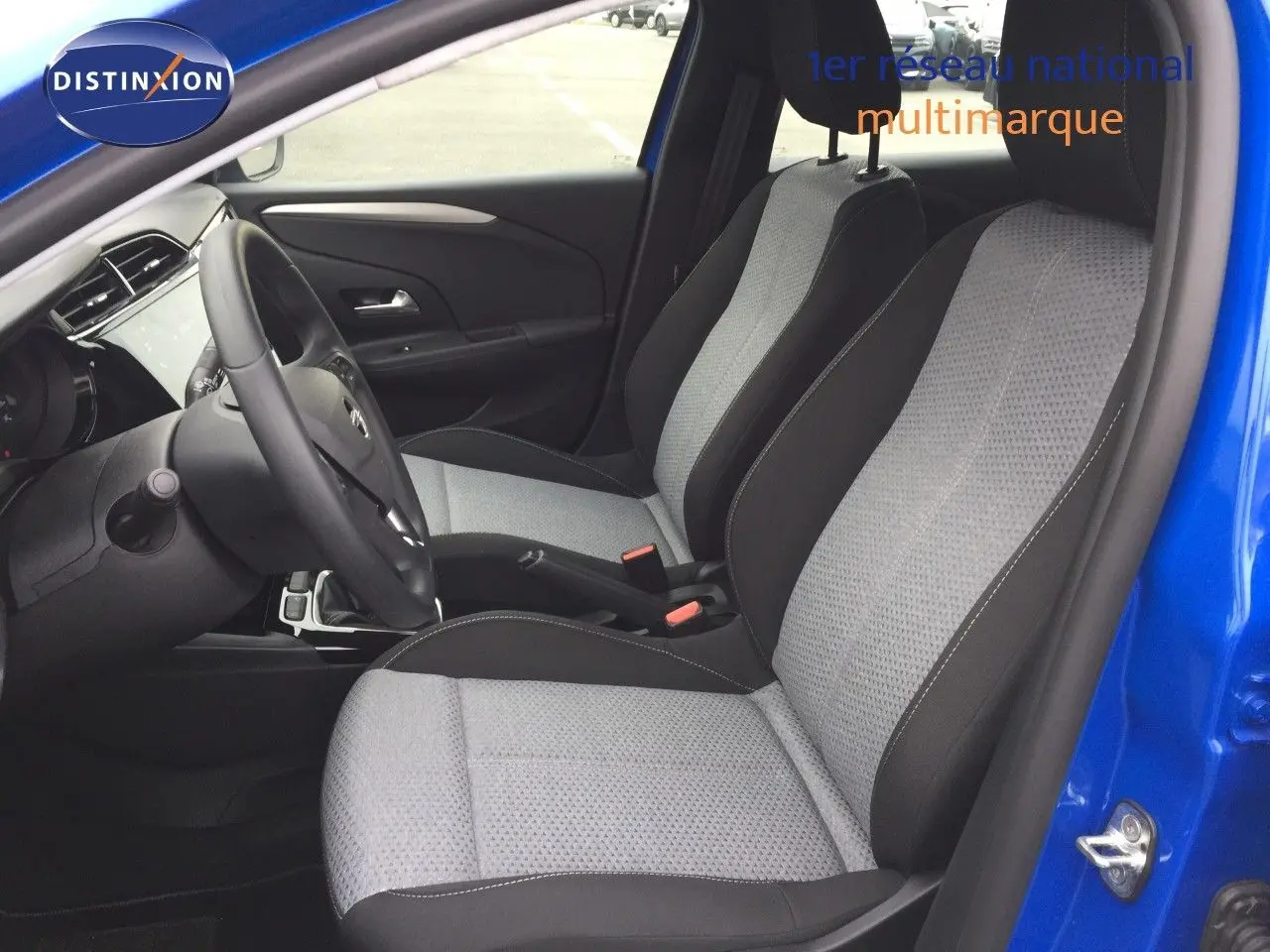 Vue intérieure côté conducteur de l'Opel Corsa bleu voltaik métal 2025, sièges tissu noir et gris clair.