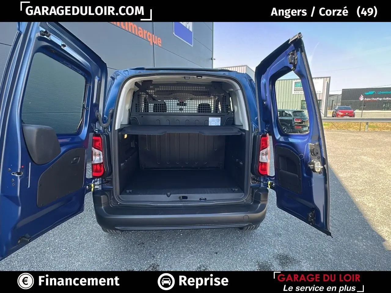 Vue arrière ouverte du Peugeot Rifter bleu 2024 montrant l'espace de chargement et les portes battantes ouvertes.