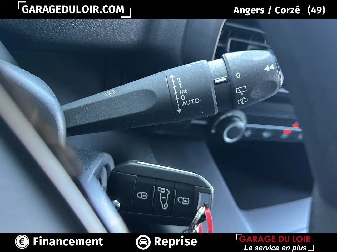 Gros plan sur la commande d'essuie-glace et la clé noire du Peugeot Rifter 2024 dans l'habitacle.