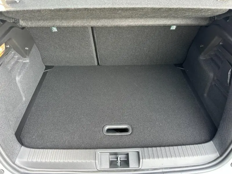 Coffre ouvert vu de face du Renault Captur 1.8 E-Tech hybride 2026, espace de chargement vide et revêtement gris.