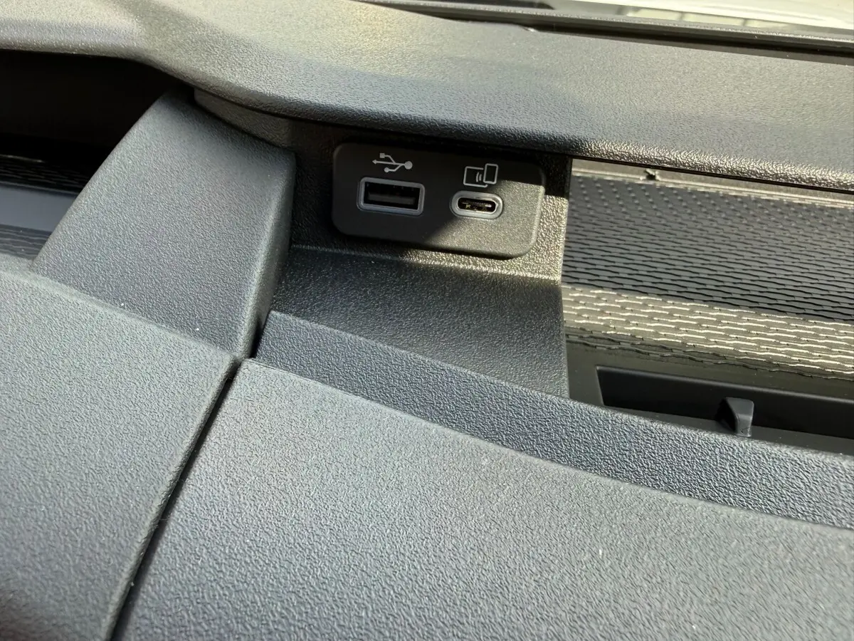 Gros plan sur les ports USB intégrés dans la console noire du tableau de bord du véhicule Iveco Daily blanc.