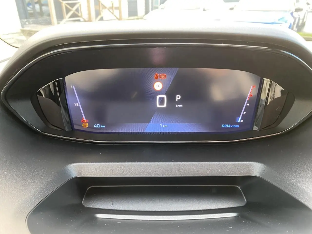 Vue rapprochée du tableau de bord numérique du Peugeot Partner Fourgon blanc, affichant la vitesse à 0 km/h.