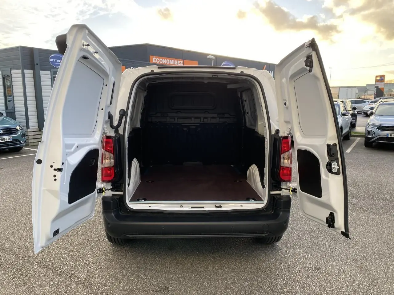 Vue arrière du Peugeot Partner Fourgon blanc 2025 avec portes arrière ouvertes montrant l'espace de chargement vide.
