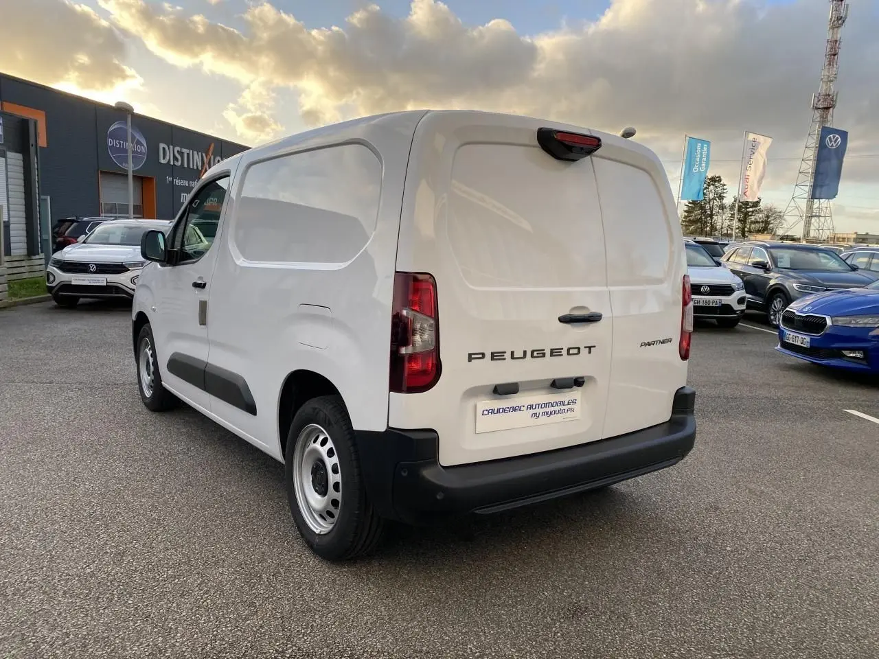 Vue 3/4 arrière droite d'un Peugeot Partner Fourgon blanc avec porte latérale coulissante et jantes tôles grises.