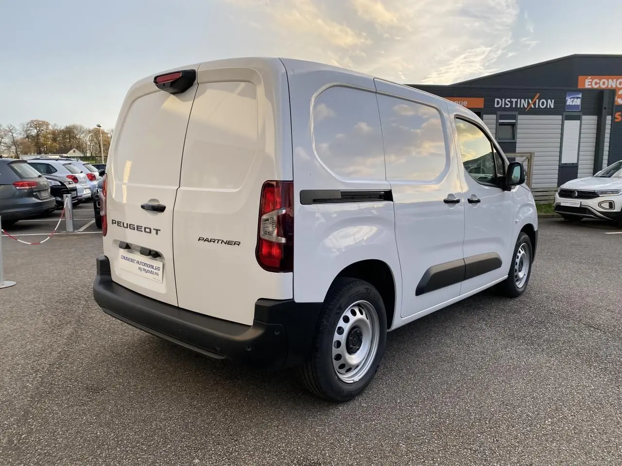 Vue 3/4 arrière droite d’un Peugeot Partner Fourgon blanc avec portes arrière battantes et jantes tôles grises.