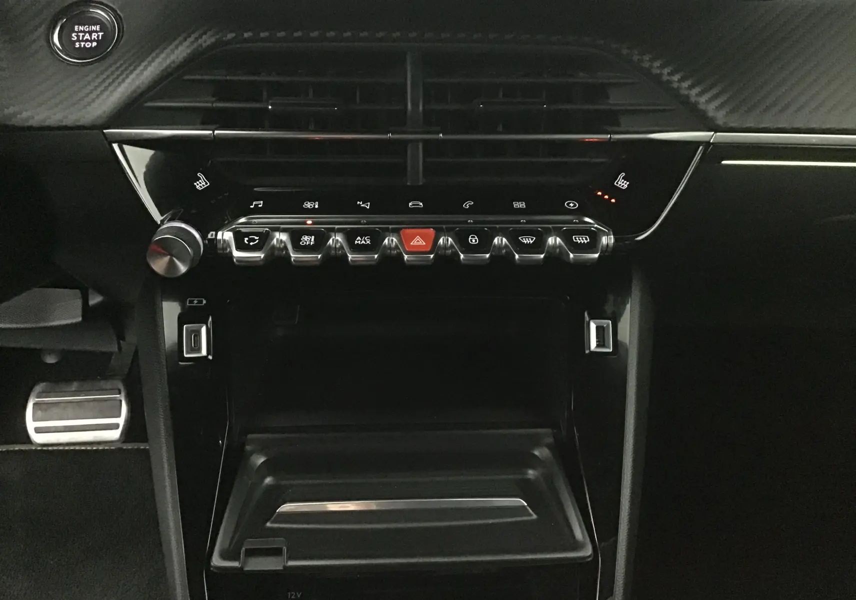 Tableau de bord noir de la Peugeot 2008 électrique 2022, avec commandes tactiles et bouton start/stop visible.