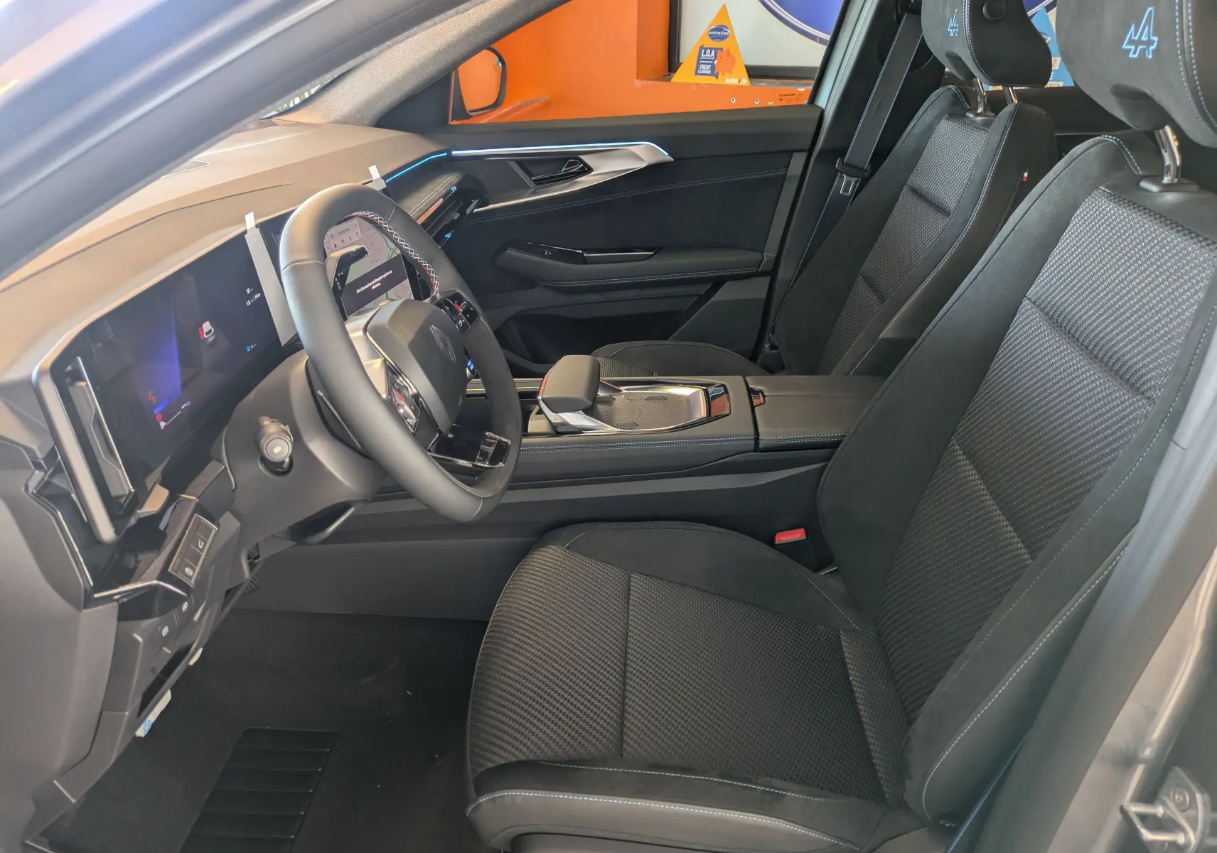 Intérieur côté conducteur du Renault Espace VI gris schiste, sièges en tissu Alcantara avec logo Alpine brodé sur appuie-têtes.