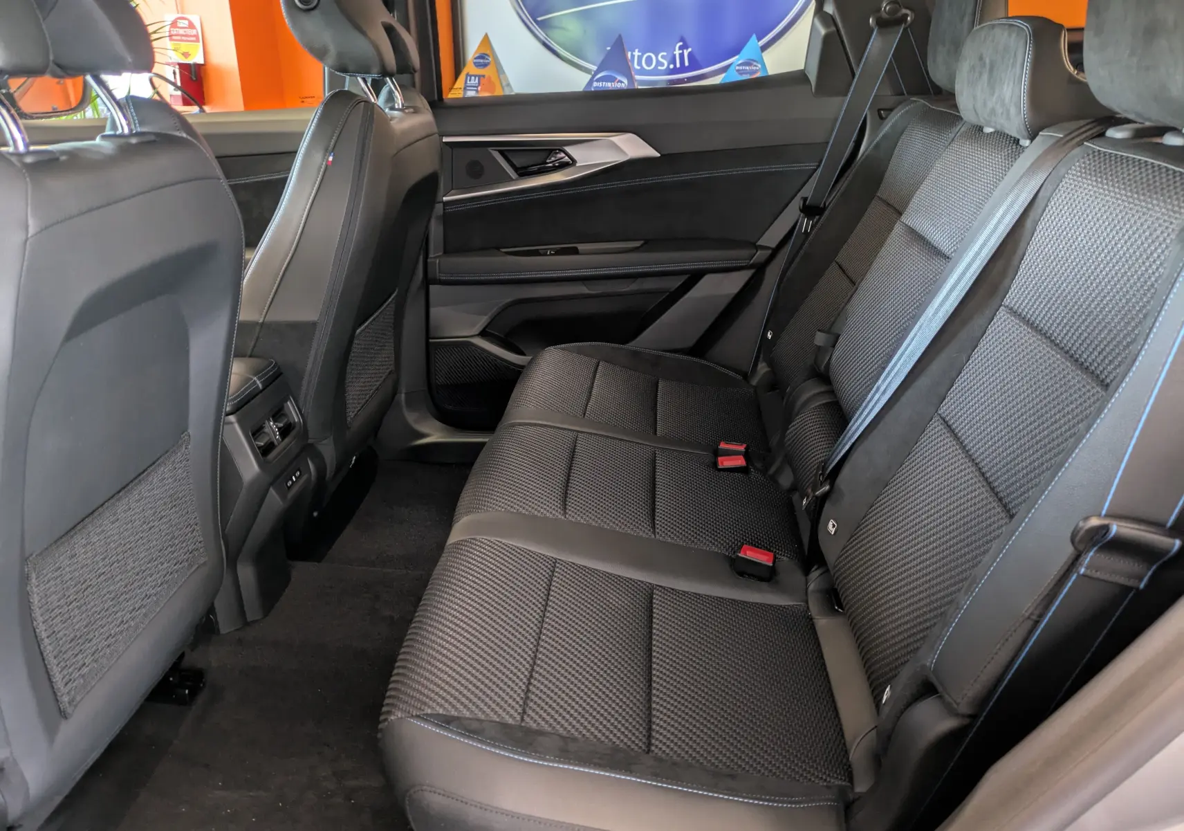 Vue intérieure arrière droite du Renault Espace VI hybride, sièges tissu et Alcantara charbon avec surpiqûres bleues