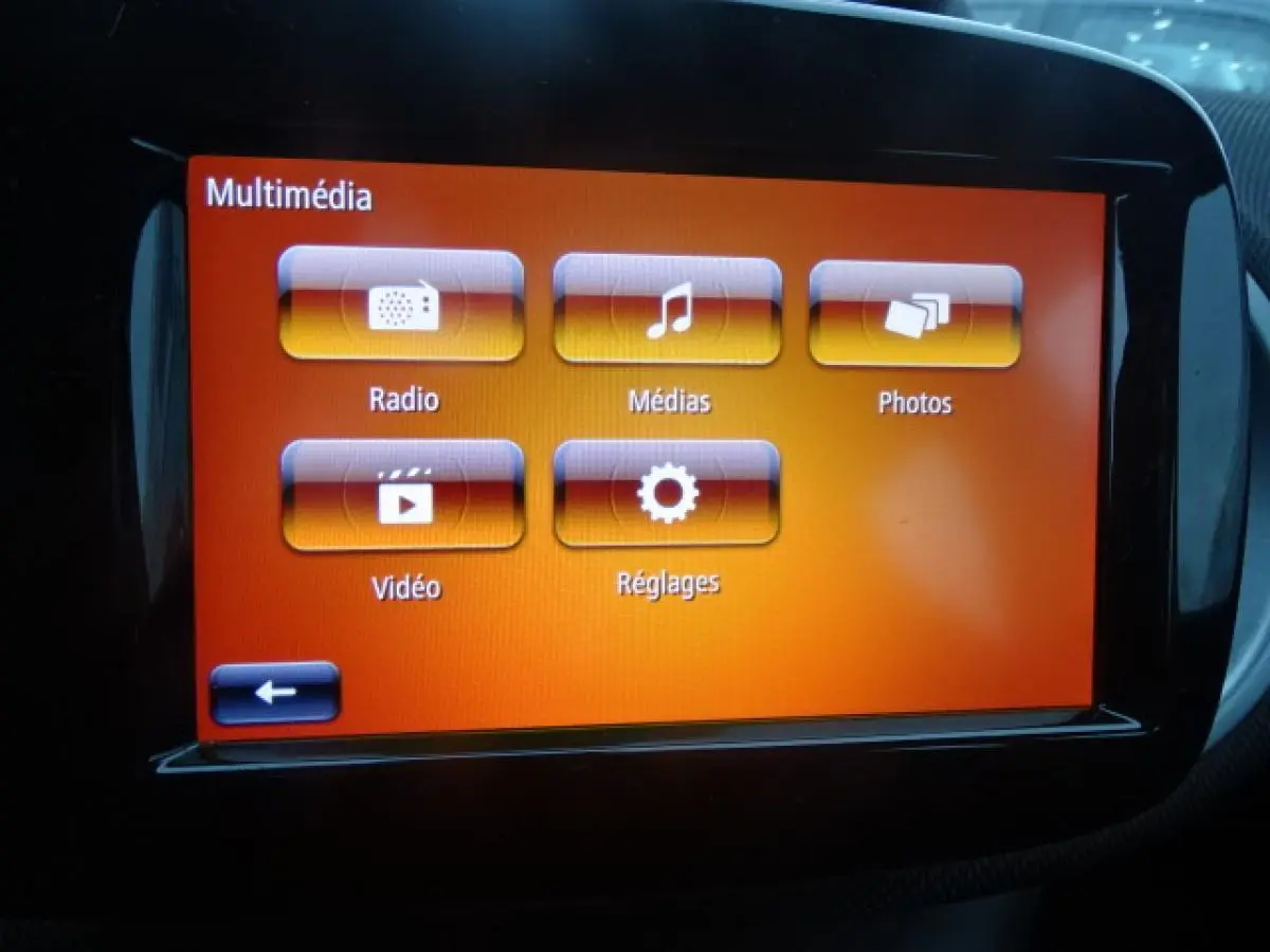 Écran tactile multimédia orange du système smart EQ forfour Electric Drive Prime, intérieur noir visible autour.