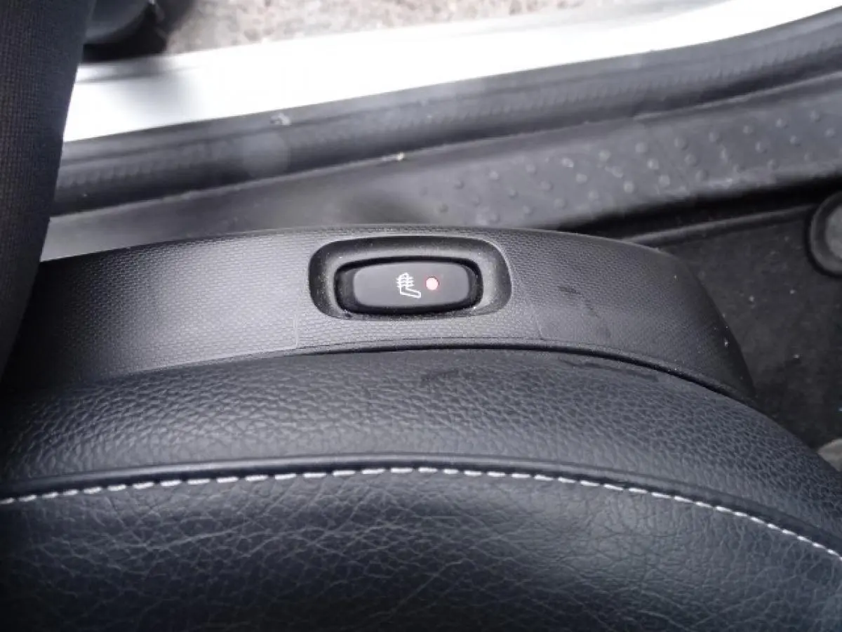 Gros plan sur le bouton de siège chauffant noir sur la sellerie cuir du Smart Forfour blanc électrique de 2018.