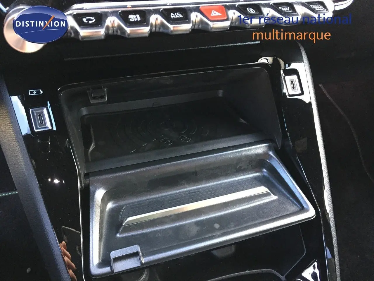 Détail de la console centrale noire brillante avec compartiment ouvert et rangée de boutons sur une Peugeot 208 Gris Artense 2025