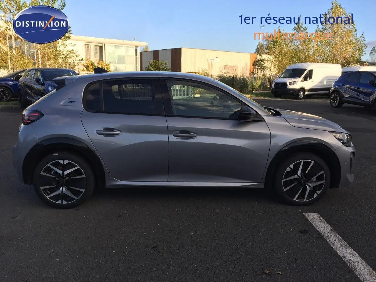 Profil côté gauche d'une Peugeot 208 GT 2025 gris Artense métal avec jantes noires et détails sportifs visibles.