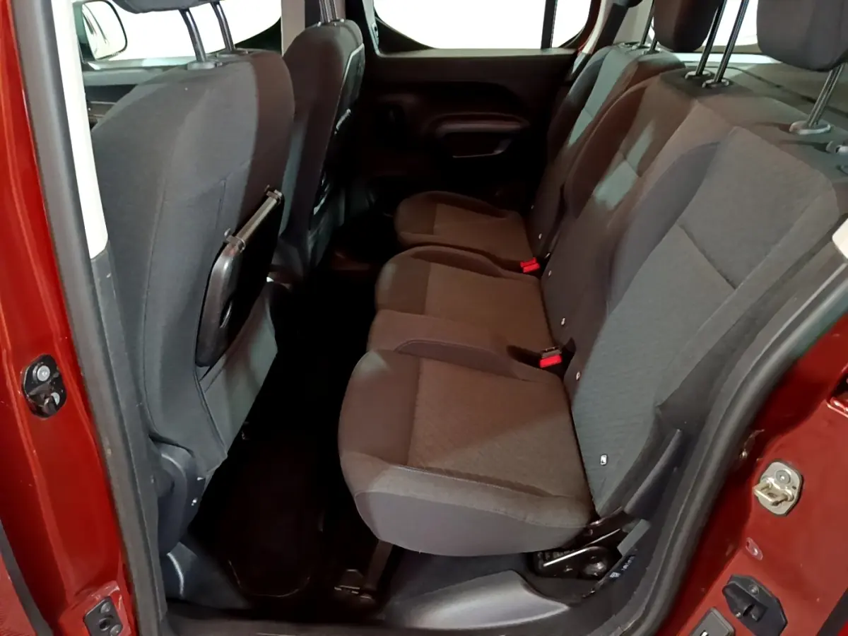 Vue côté droit sur les sièges arrière gris du Peugeot Rifter marron, porte ouverte et intérieur spacieux visible.