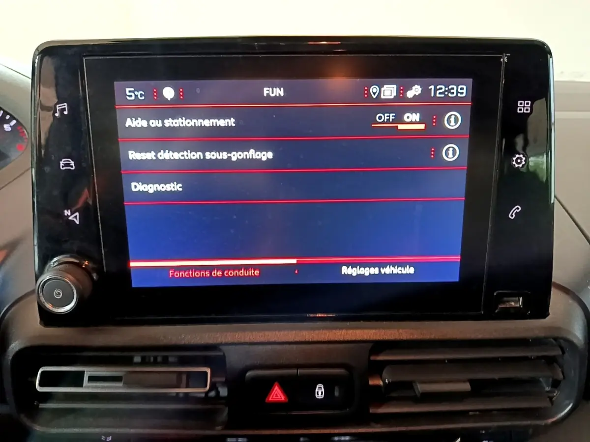 Écran tactile central du tableau de bord du Peugeot Rifter marron 2019 affichant les réglages d'aide au stationnement.