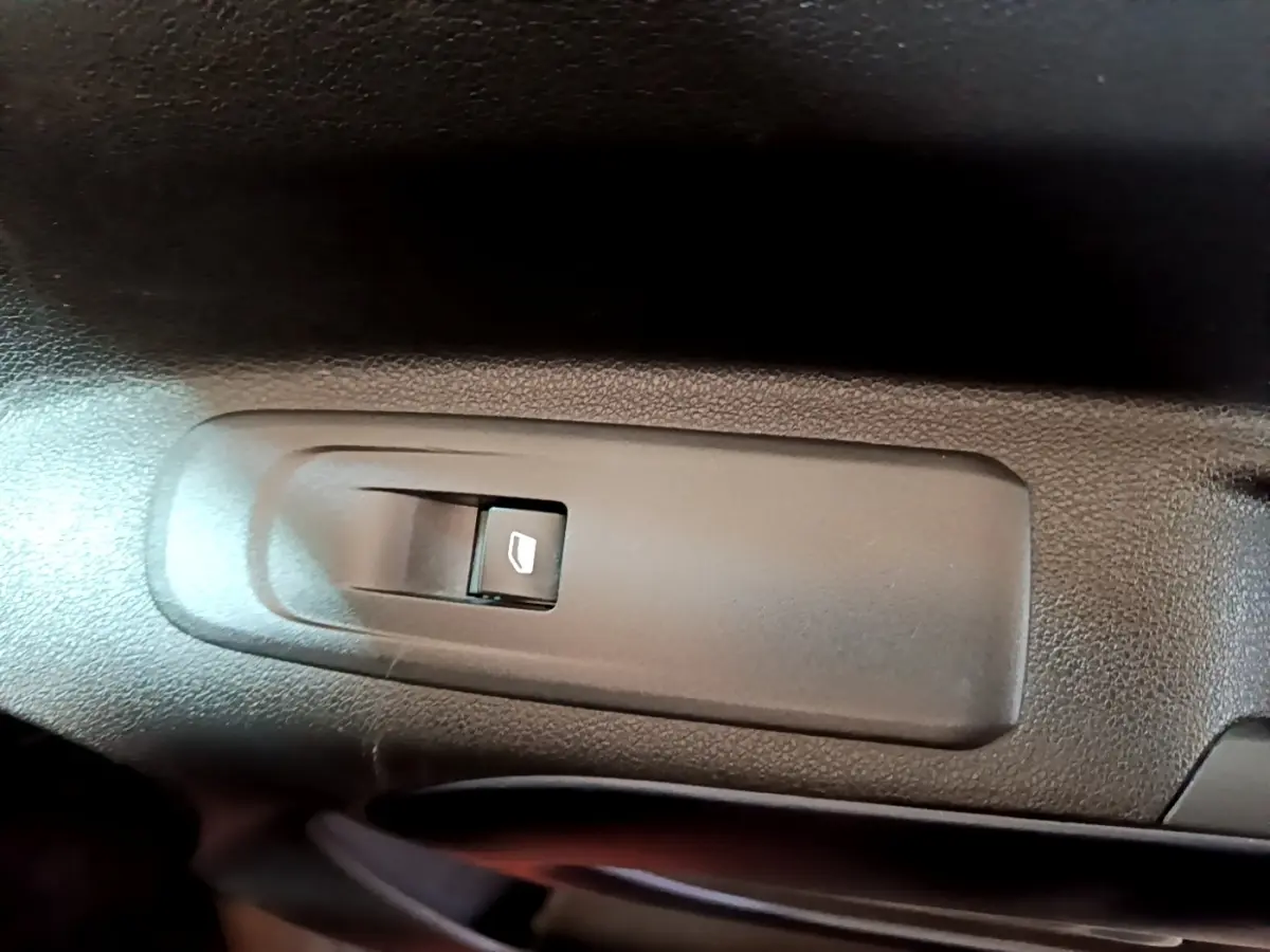 Bouton de commande de lève-vitre électrique côté conducteur dans l'habitacle du Peugeot Rifter marron 2019.