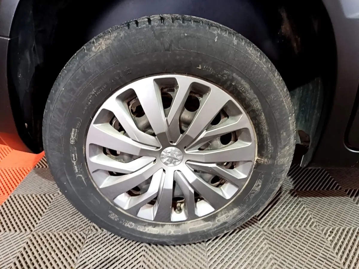 Gros plan sur la roue avant gauche du Peugeot Rifter marron 2019 avec jante alliage au design moderne.