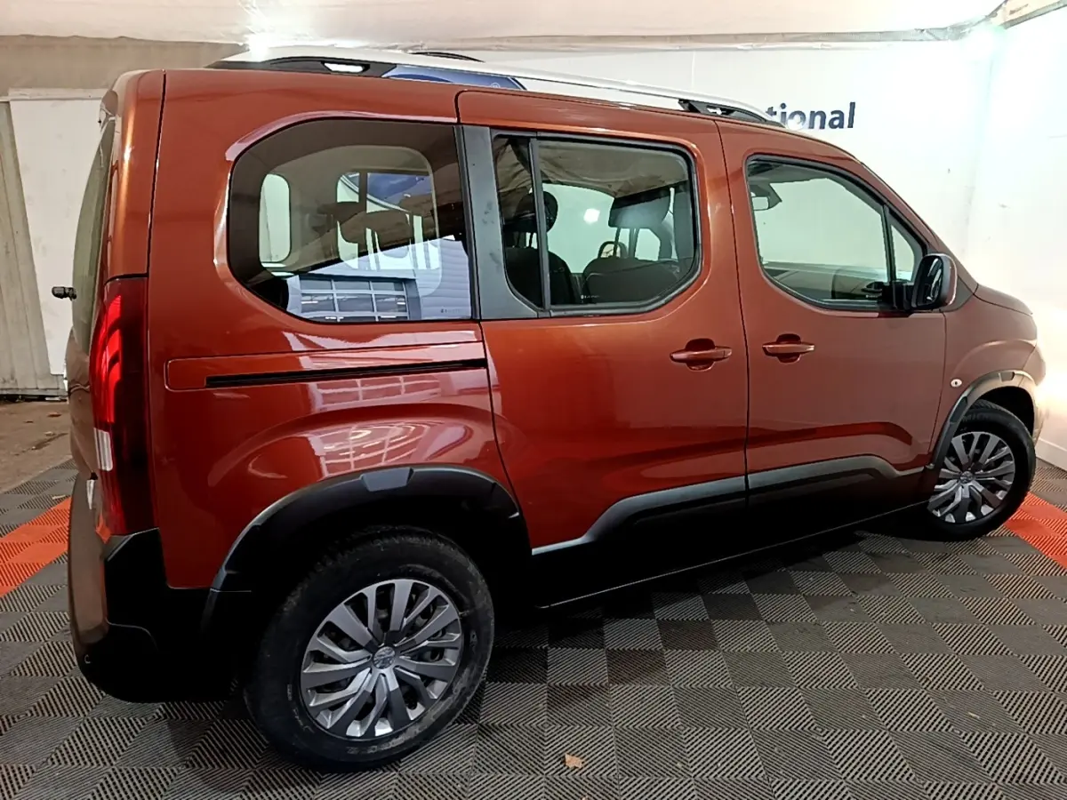 Vue latérale droite d'un Peugeot Rifter BlueHDi 100 Allure marron avec barres de toit chromées et jantes alliage.