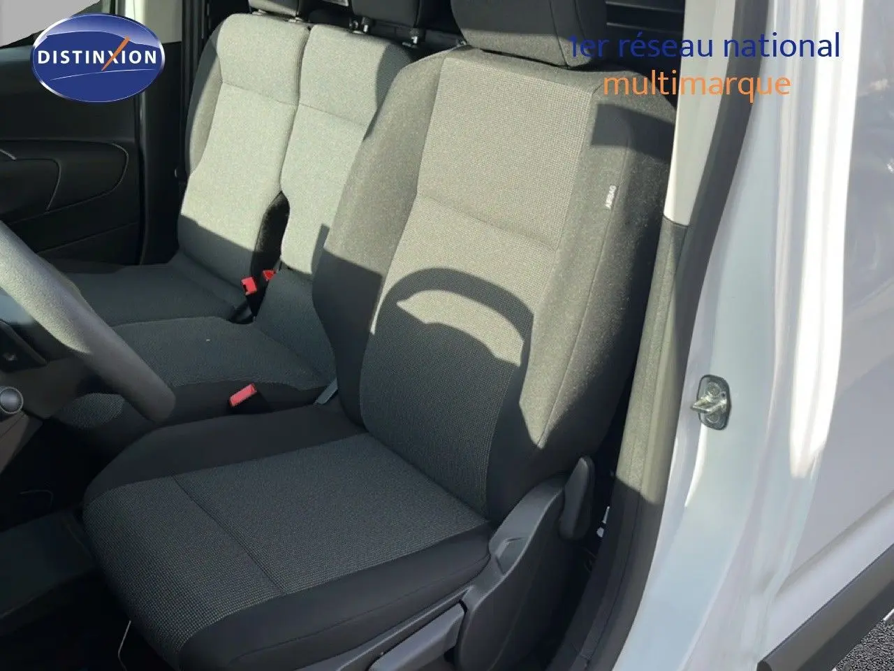 Vue intérieure côté droit du siège avant en tissu gris du Citroën Berlingo blanc Icy 2025, porte ouverte.