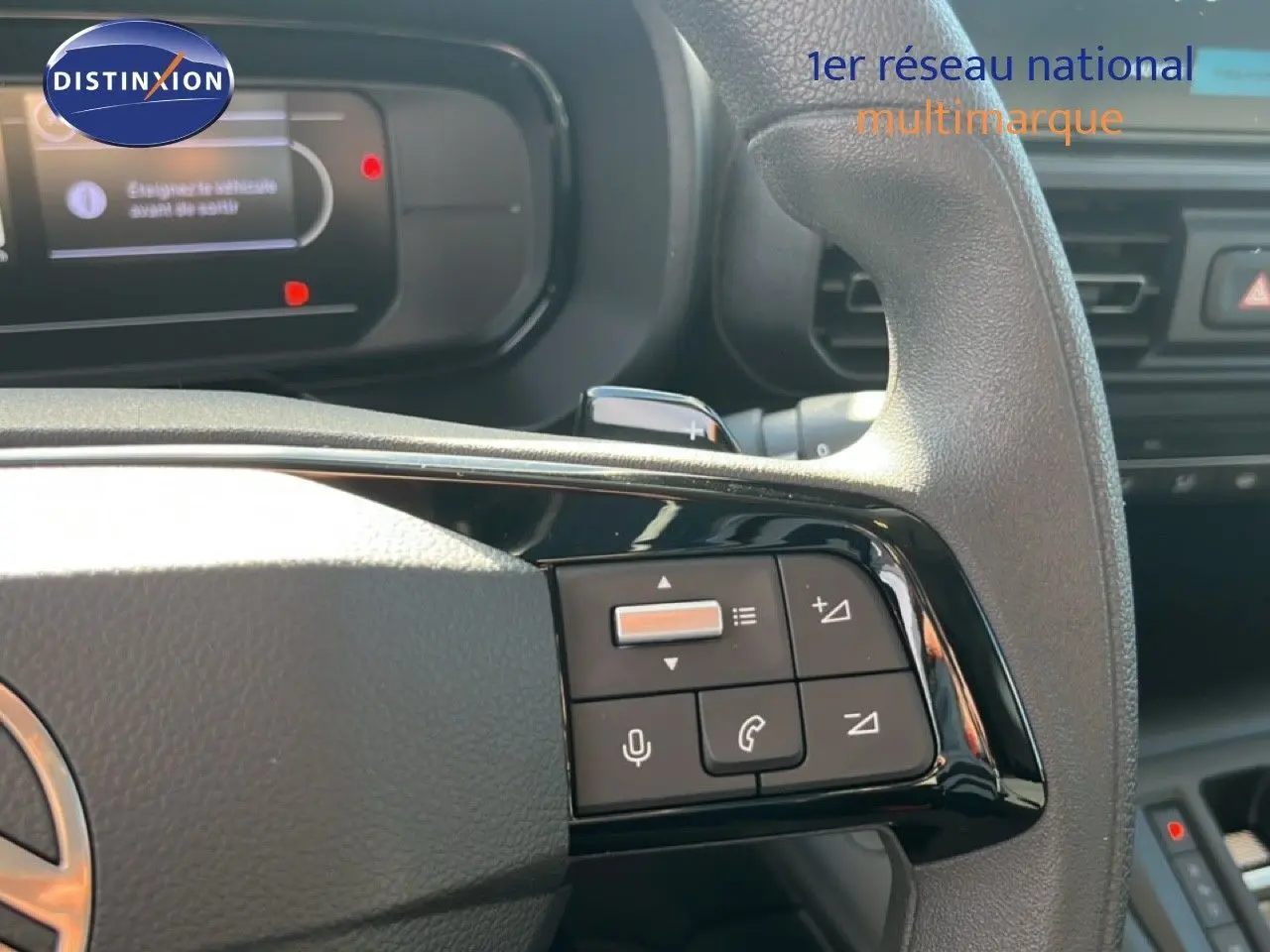 Gros plan sur le volant multifonction du Citroën Berlingo 2025, mettant en valeur les commandes audio et téléphone.