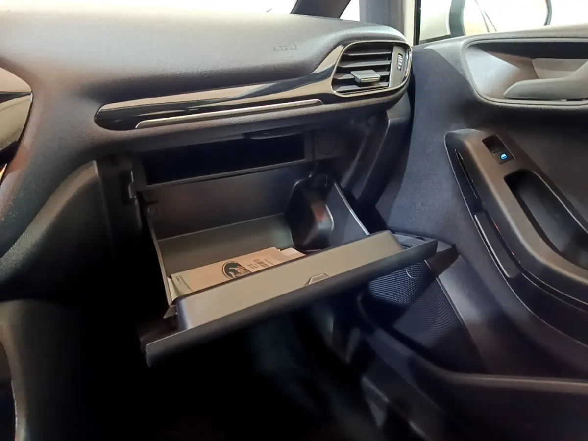 Intérieur de la Ford Fiesta 2022 blanc, vue côté passager sur boîte à gants ouverte et porte avec commande de vitre.