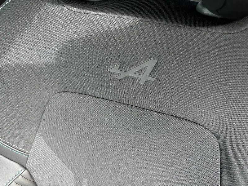 Détail du tissu gris avec logo Alpine embossé sur le siège avant du Renault Captur Blanc Nacré/Noir Etoile 2026.