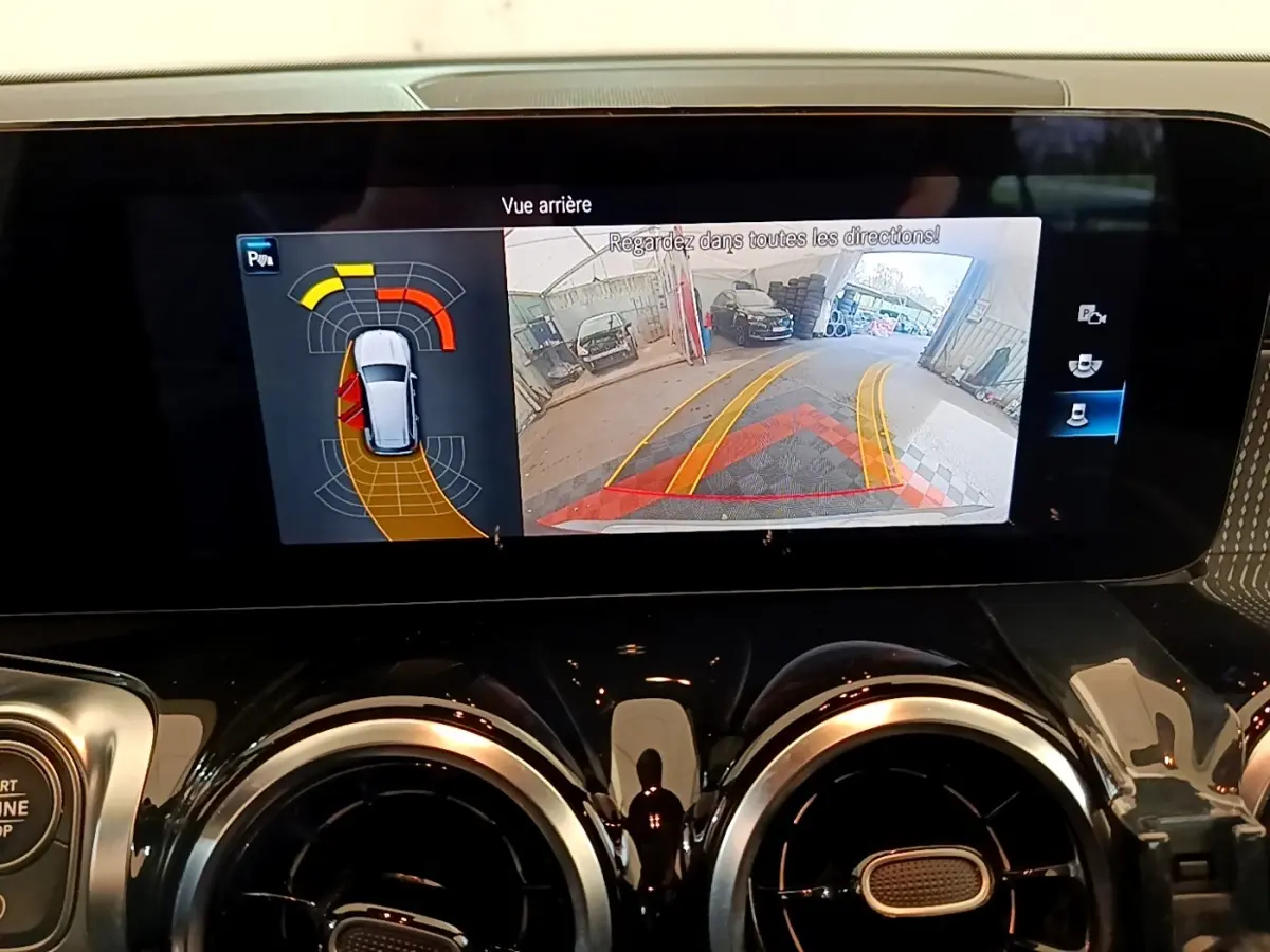 Écran tactile intérieur du Mercedes GLB 200 d 2021 affichant la caméra de recul et l’aide au stationnement.
