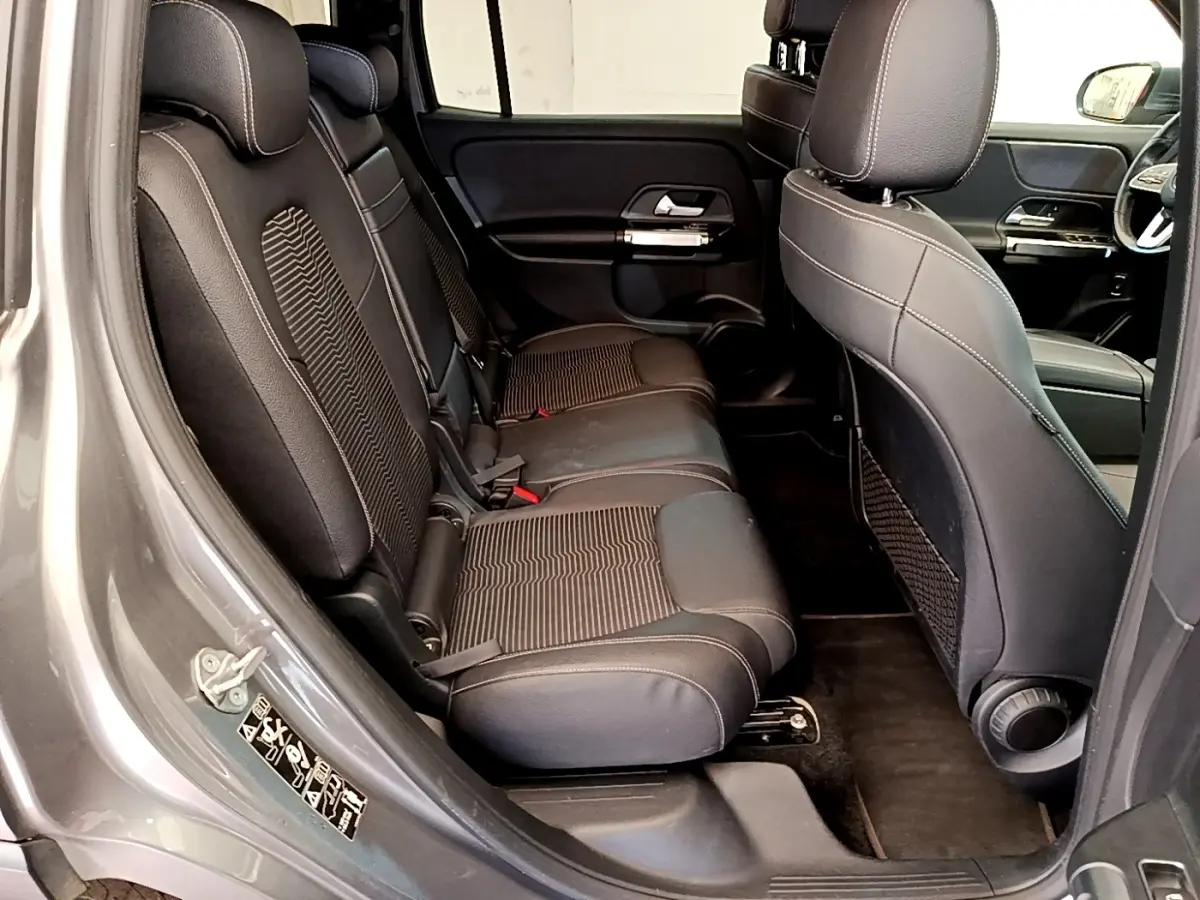 Vue intérieure côté gauche sur la banquette arrière en tissu noir du Mercedes GLB 200 d Business Line gris foncé.