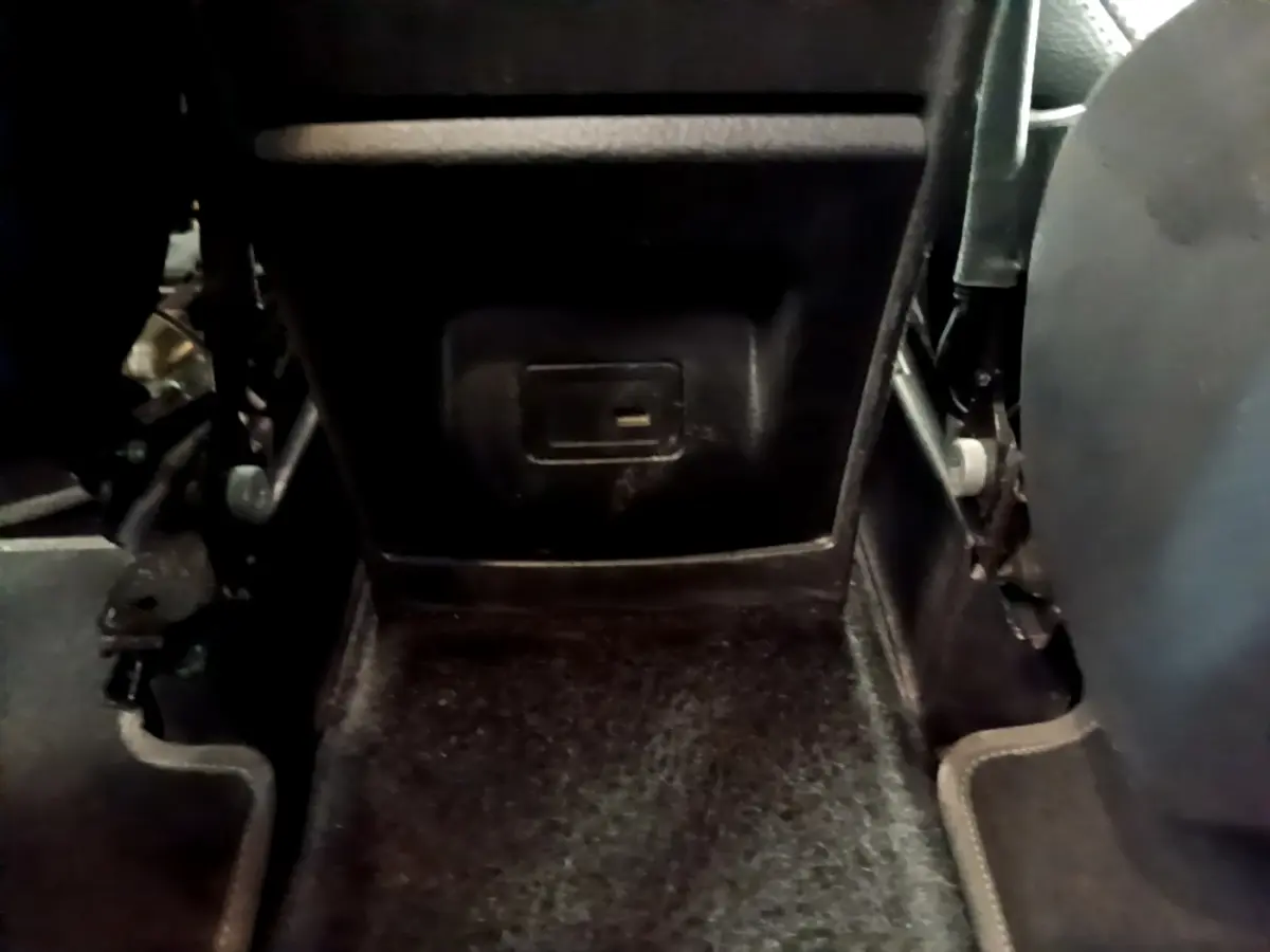 Détail du plancher arrière noir du Mercedes GLB 200 d Business Line 2021, avec prise électrique sous le siège.