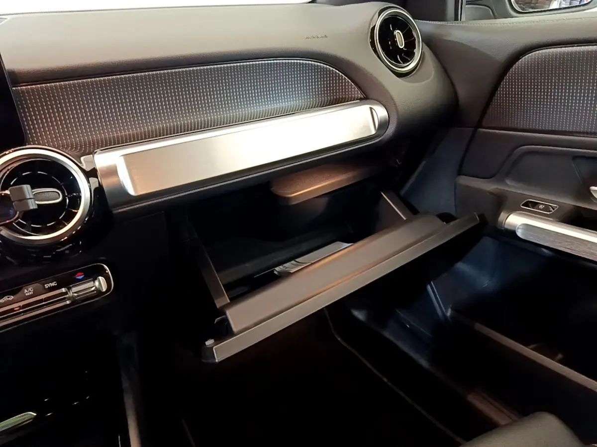 Vue intérieure côté passager du tableau de bord gris foncé et boîte à gants ouverte du Mercedes GLB 200 d Business Line 2021.
