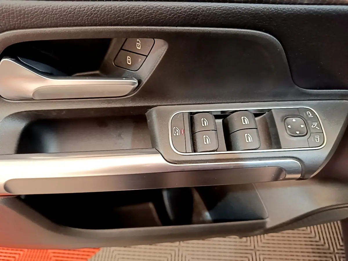 Gros plan sur la porte côté conducteur du Mercedes GLB 200 d Business Line 2021, avec commandes vitres et poignée alu.