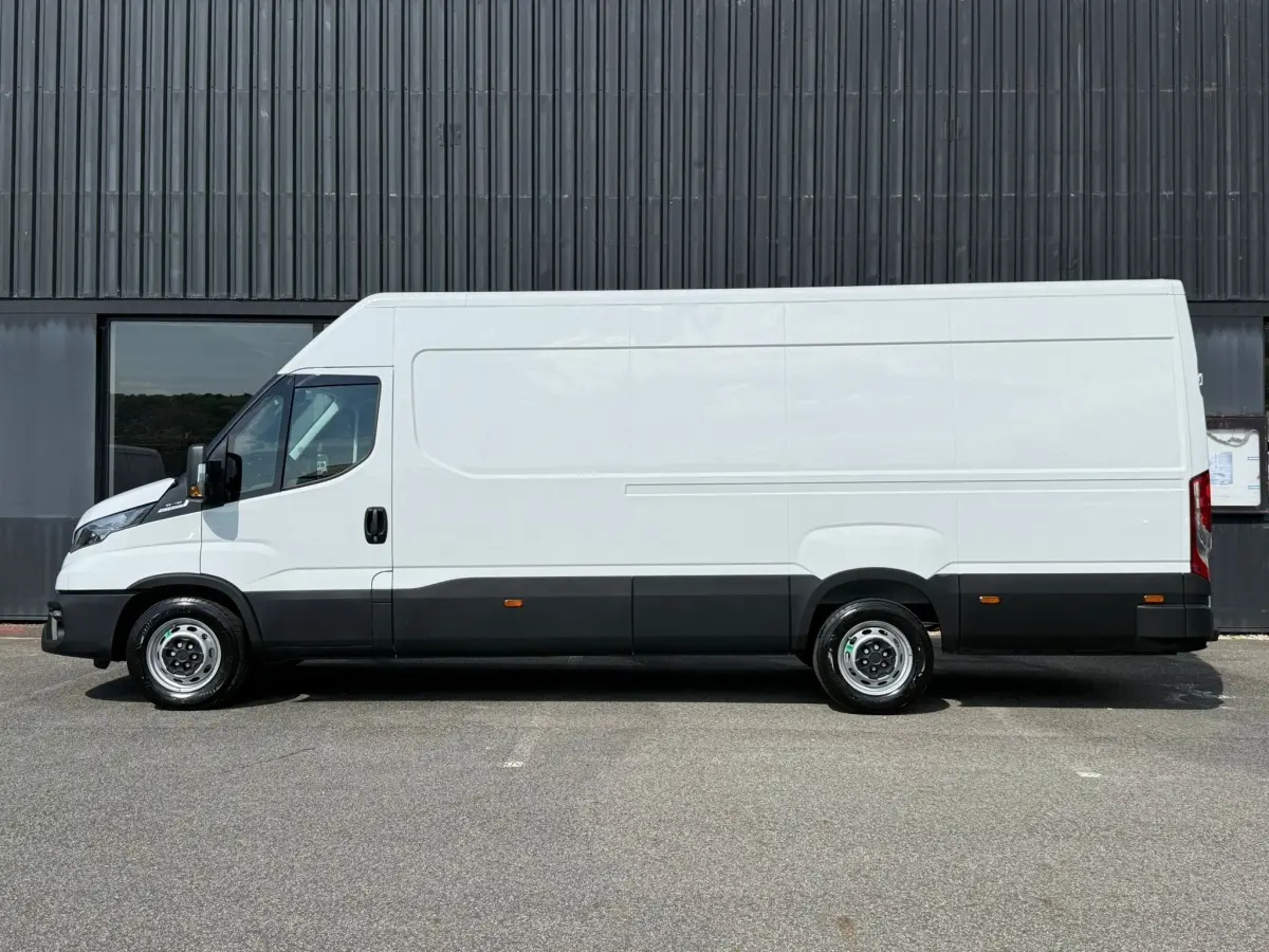 Vue latérale droite d’un Iveco Daily blanc 35S18 3.0 V16 Himatic 2026 avec bas de caisse noir et jantes acier.