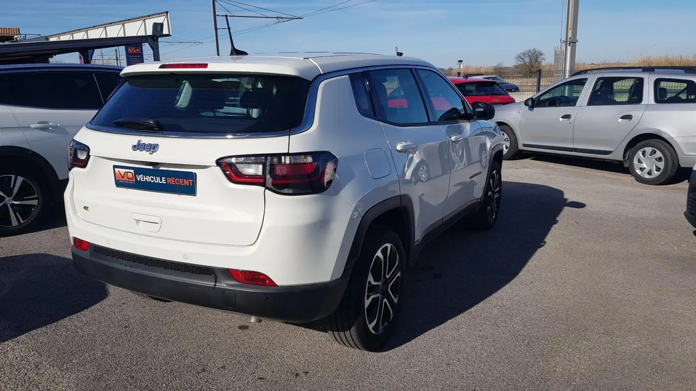 Jeep Compass blanc vue 3/4 arrière droit, avec jantes alliage 18 pouces et feux arrière LED.
