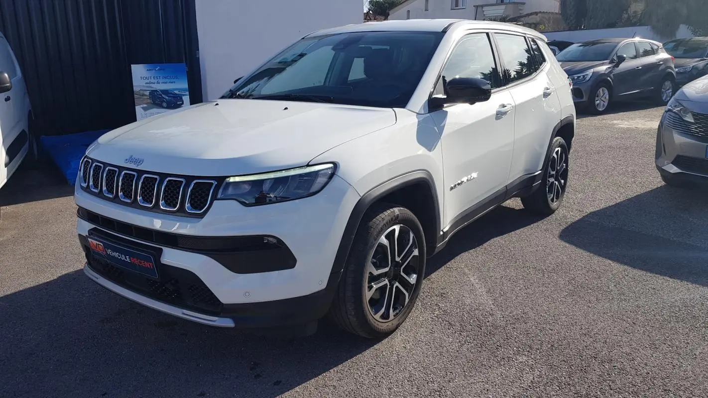 Jeep Compass blanc vue 3/4 avant droit, jantes alliage 18 pouces et calandre caractéristique à sept fentes.