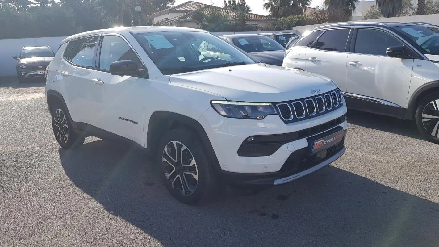 Jeep Compass blanc en 3/4 avant droit, avec jantes alliage 18 pouces et calandre à sept fentes distinctives.