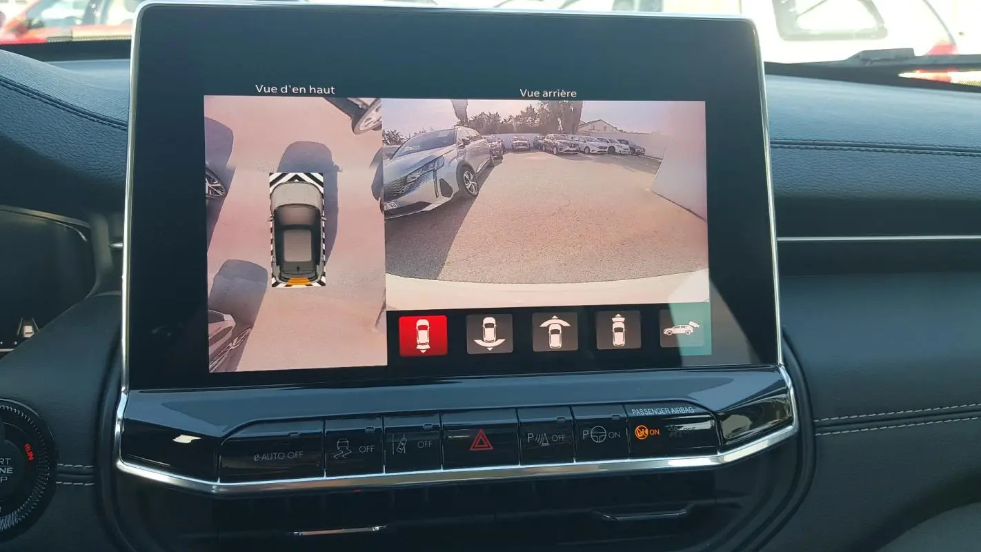 Écran tactile intérieur montrant la caméra de recul et vue en hauteur du Jeep Compass blanc 2024.