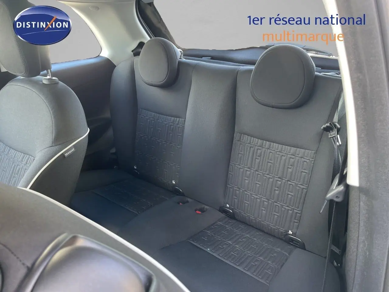 Vue intérieure arrière montrant les sièges noirs avec motif FIAT embossé sur une Fiat 500 électrique 2023.
