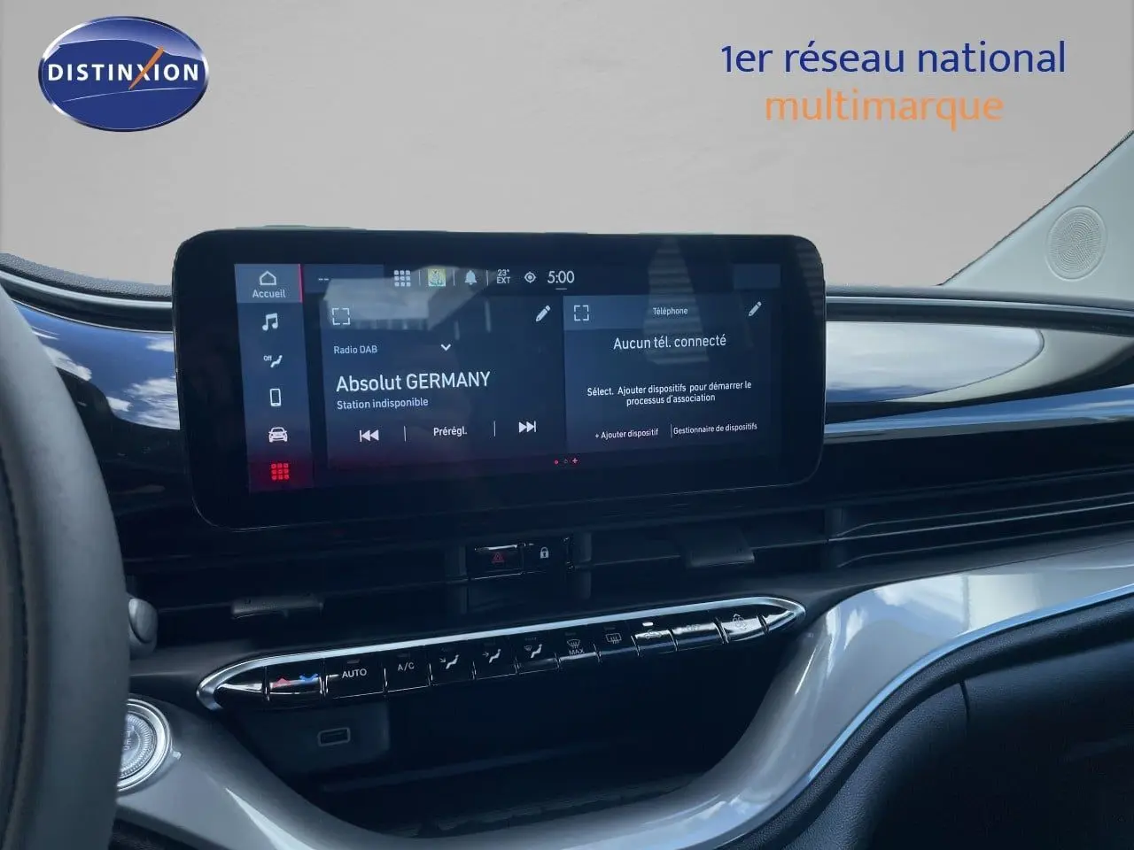 Vue intérieure du tableau de bord de la Fiat 500 électrique 2023, écran tactile central et commandes climatisation visibles.
