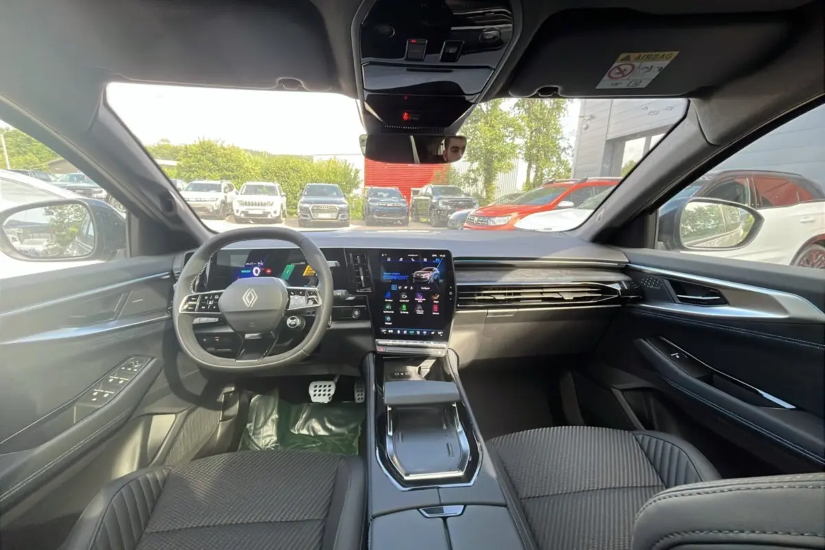 Vue intérieure avant du Renault Austral 200 Esprit Alpine, tableau de bord moderne avec écran tactile vertical et volant multifonctions cuir.