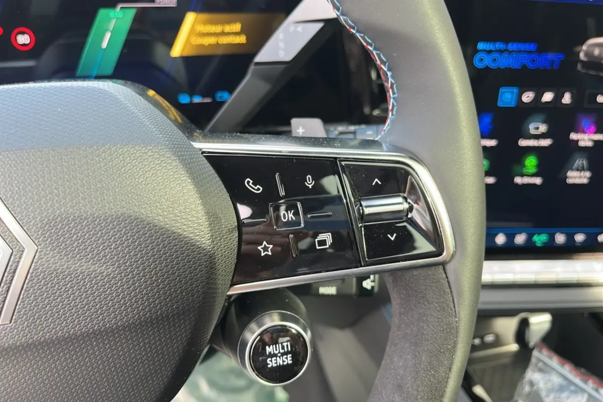 Gros plan sur le volant cuir multifonctions du Renault Austral 200 Esprit Alpine avec commandes et molette Multi-Sense.