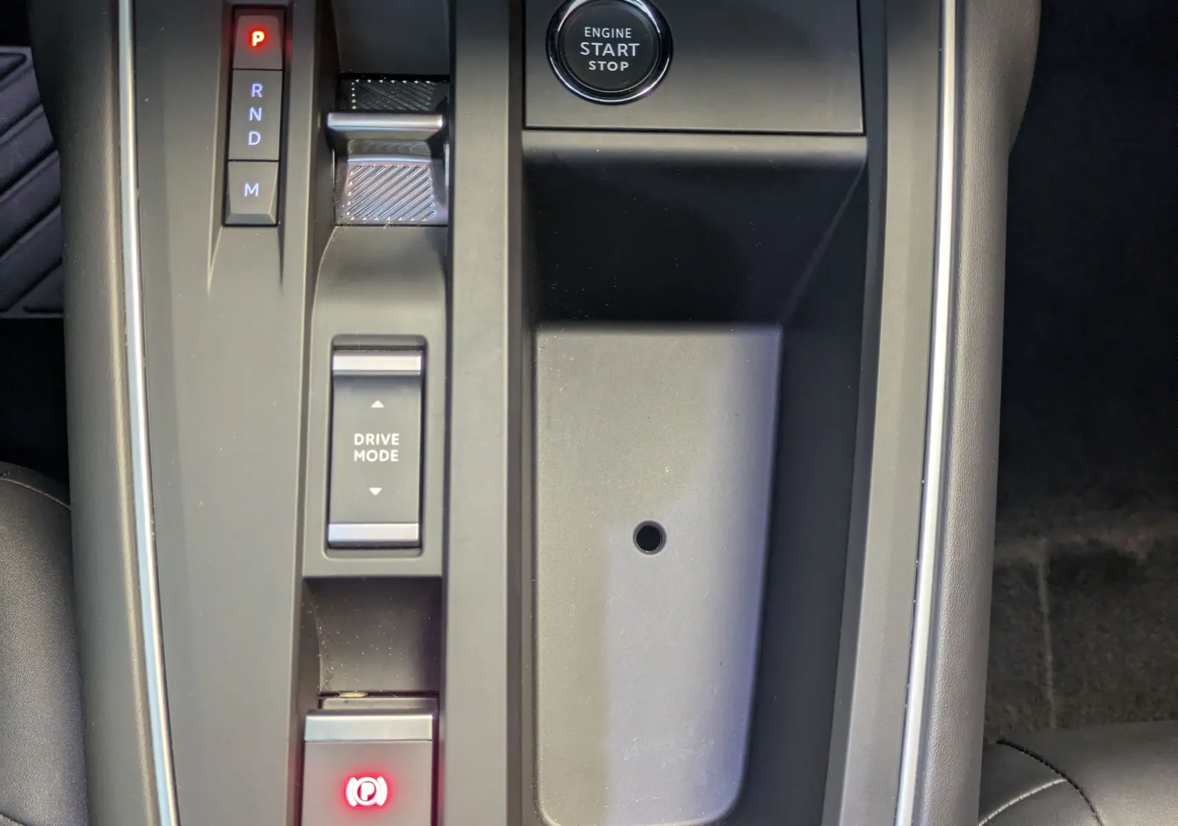 Vue rapprochée de la console centrale noire du Citroën C5 Aircross hybride 2024 avec bouton start/stop et levier de vitesses automatique.