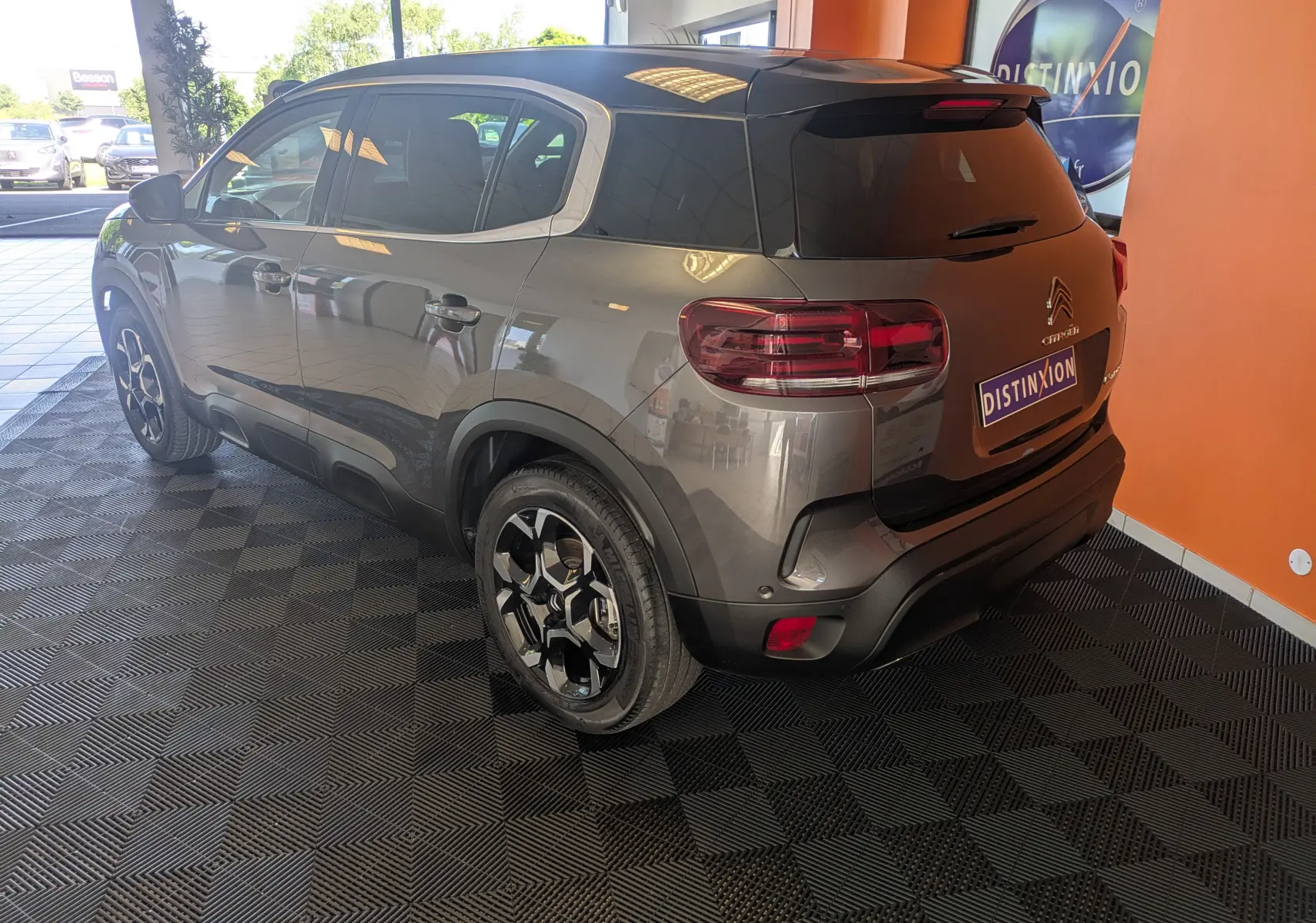 Vue 3/4 arrière droite du Citroën C5 Aircross hybride gris platinium avec toit noir et jantes alliage 18 pouces.