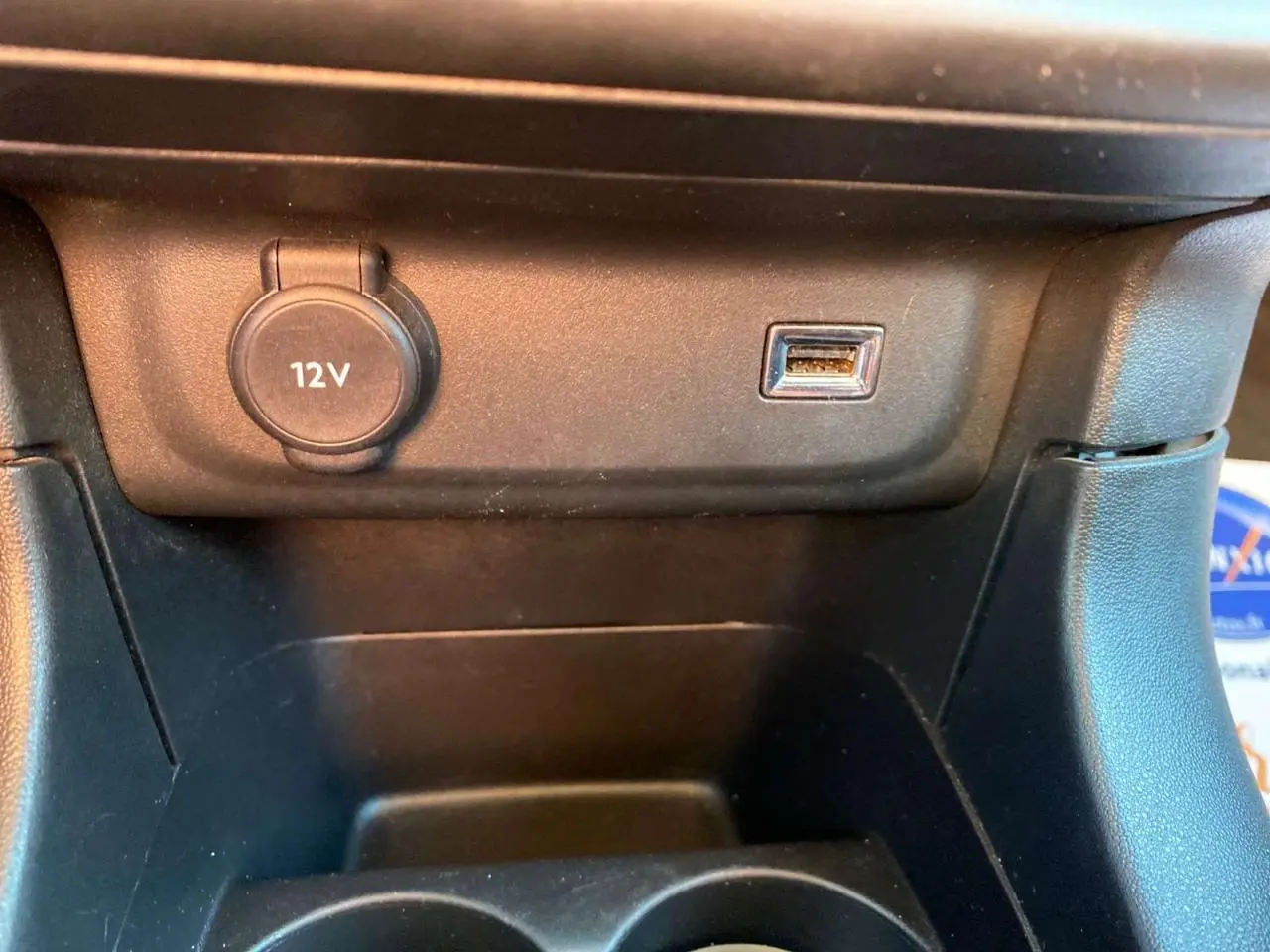 Prise 12V et port USB en gros plan sur la console centrale intérieure d'une Citroën C3 Gris Artense 2022.