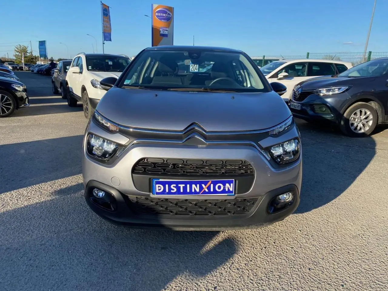 Vue frontale d'une Citroën C3 gris Artense 2022 avec calandre noire et phares LED distinctifs.