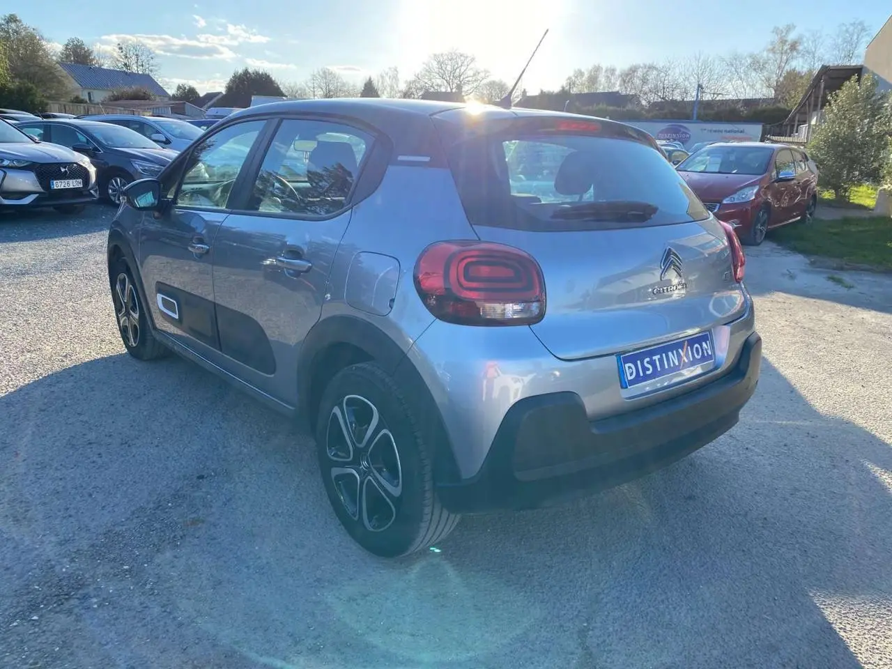 Citroën C3 gris Artense vue 3/4 arrière droit, avec protections latérales noires et jantes spécifiques.