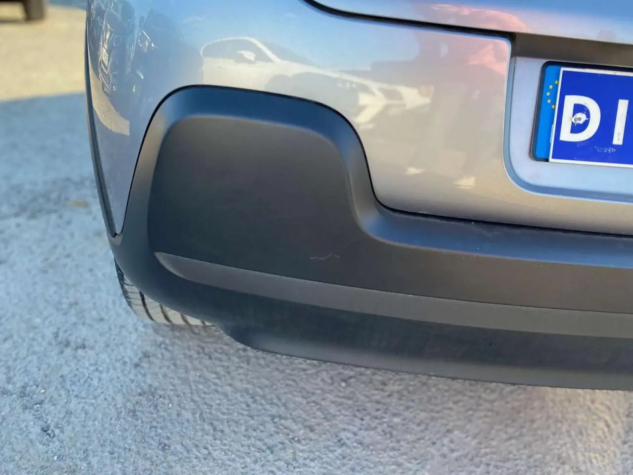 Gros plan sur le pare-chocs arrière gris Artense d'une Citroën C3 2022 avec partie inférieure noire mate.