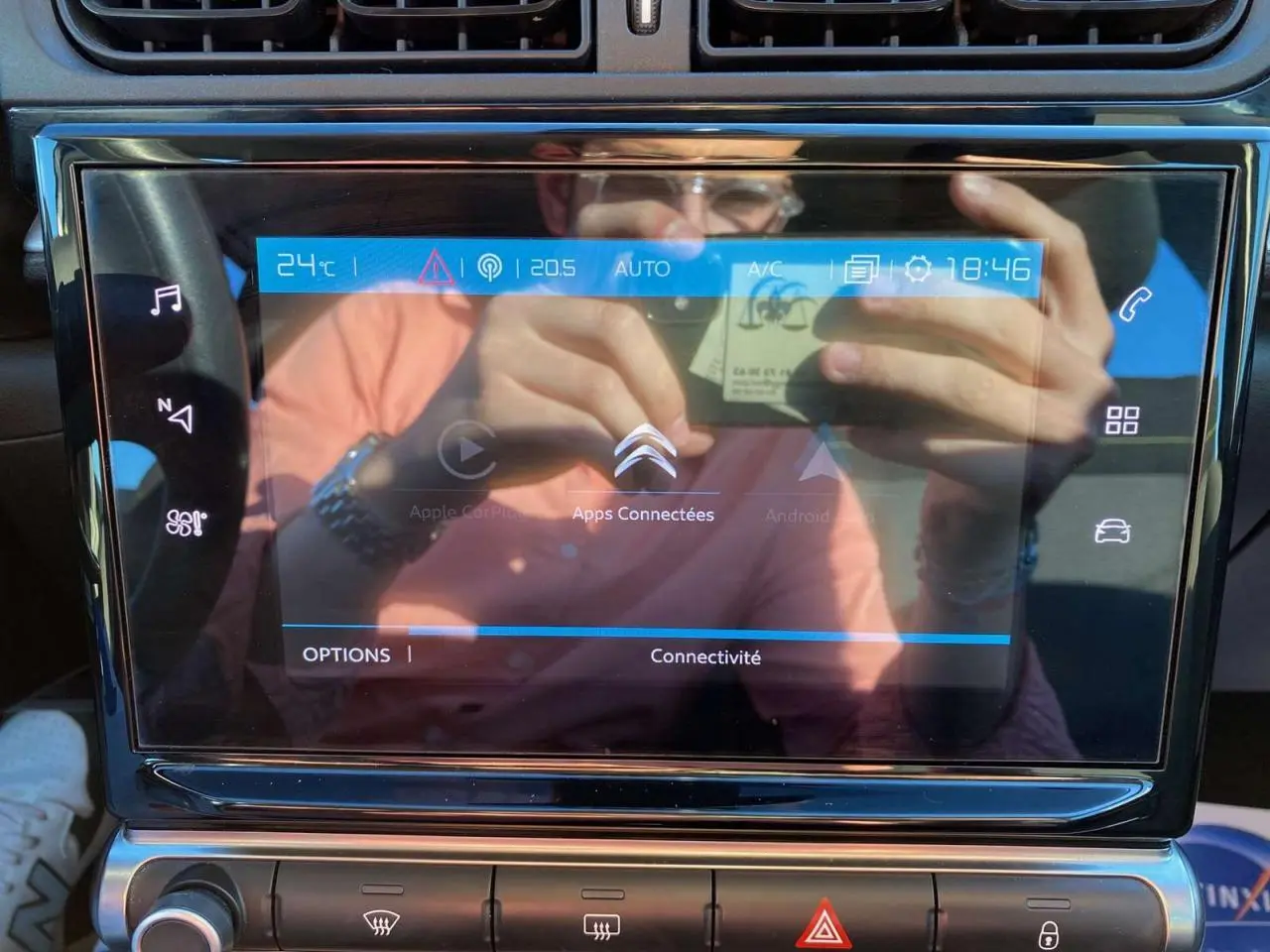 Écran tactile central de la Citroën C3 Gris Artense 2022 affichant les options connectées avec reflets du conducteur.