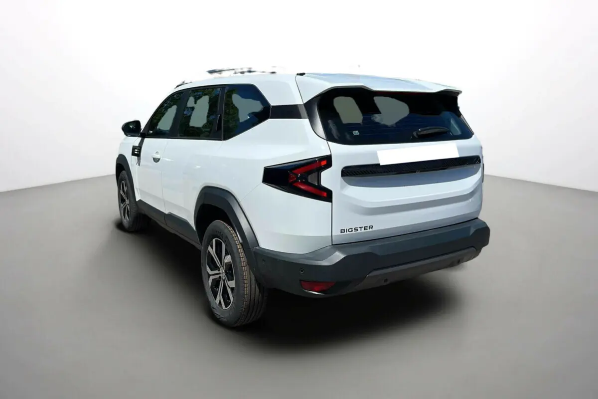 Vue 3/4 arrière droite du Dacia Bigster blanc glacier avec barres de toit et jantes alu 17 pouces.