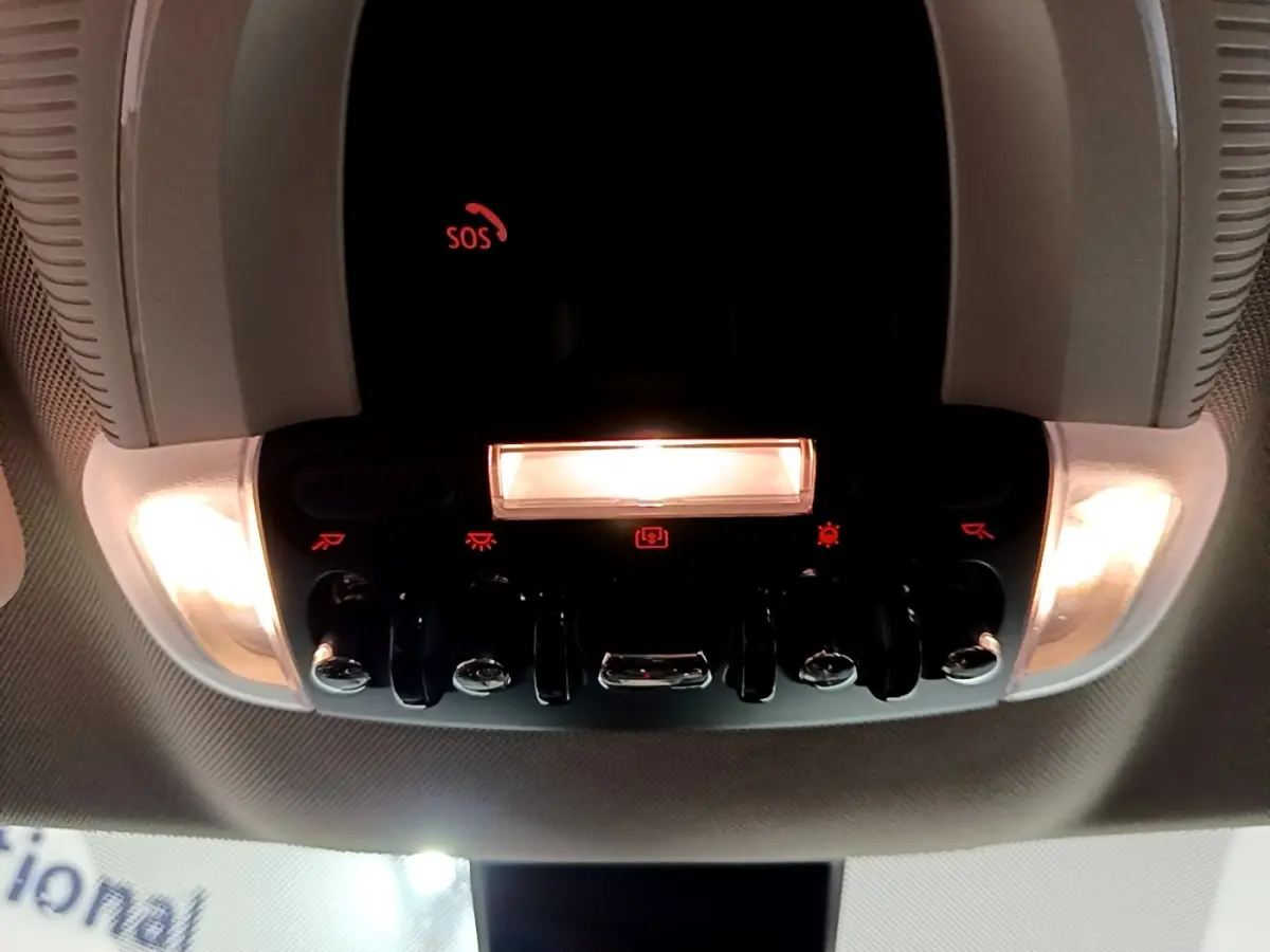 Vue en contre-plongée du panneau de commandes lumineux intérieur du toit d’un MINI Countryman gris clair 2022.