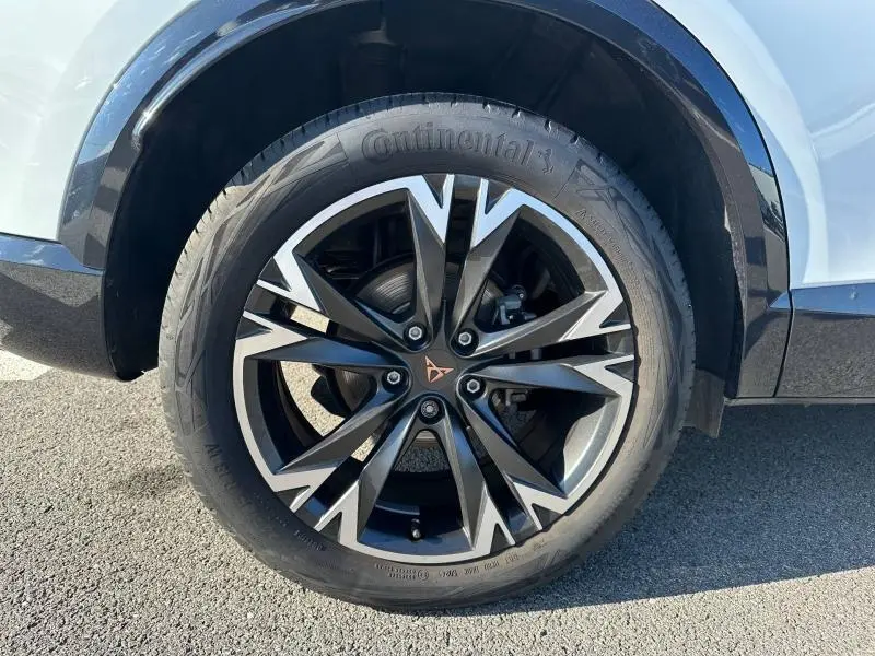 Gros plan sur la roue avant droite du CUPRA Formentor blanc Nevada métallisé avec jante alliage noire et argentée distinctive.